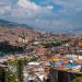 Panoramic view of Medellín's vibrant cityscape and mountains under a clear sky.
