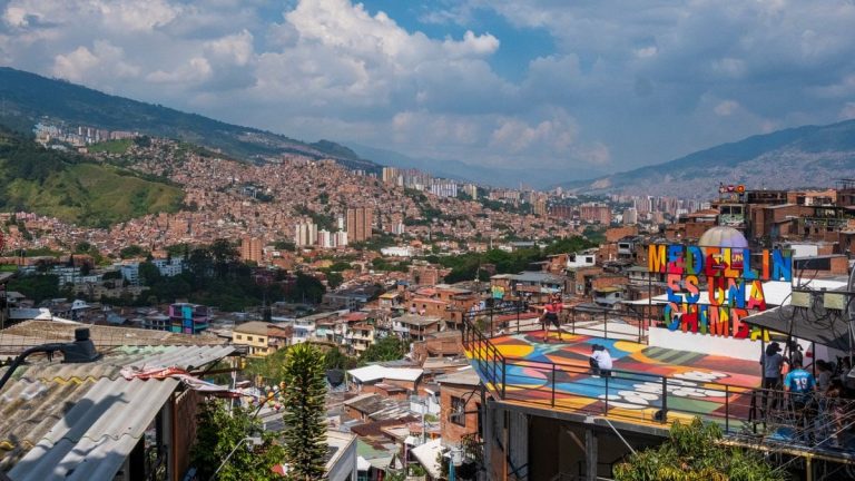 Panoramic view of Medellín's vibrant cityscape and mountains under a clear sky.